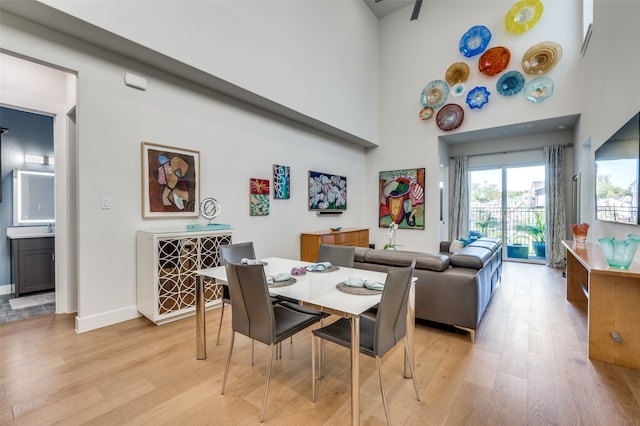 dining area with a high ceiling and light wood-type flooring