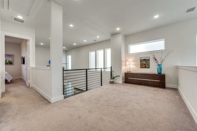 hall with light colored carpet