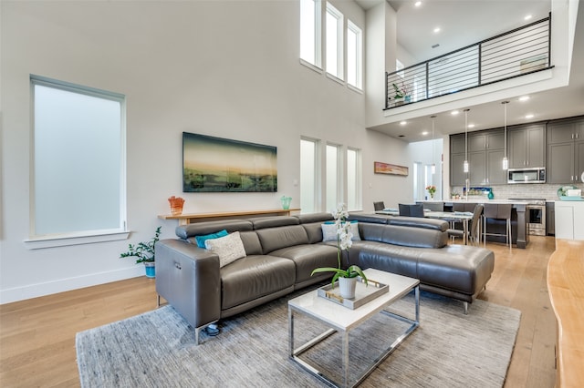 living room with light hardwood / wood-style floors and a high ceiling