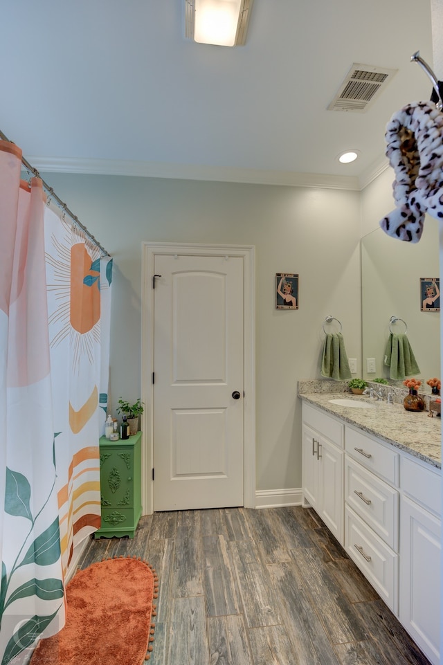 bathroom with vanity, ornamental molding, and hardwood / wood-style floors