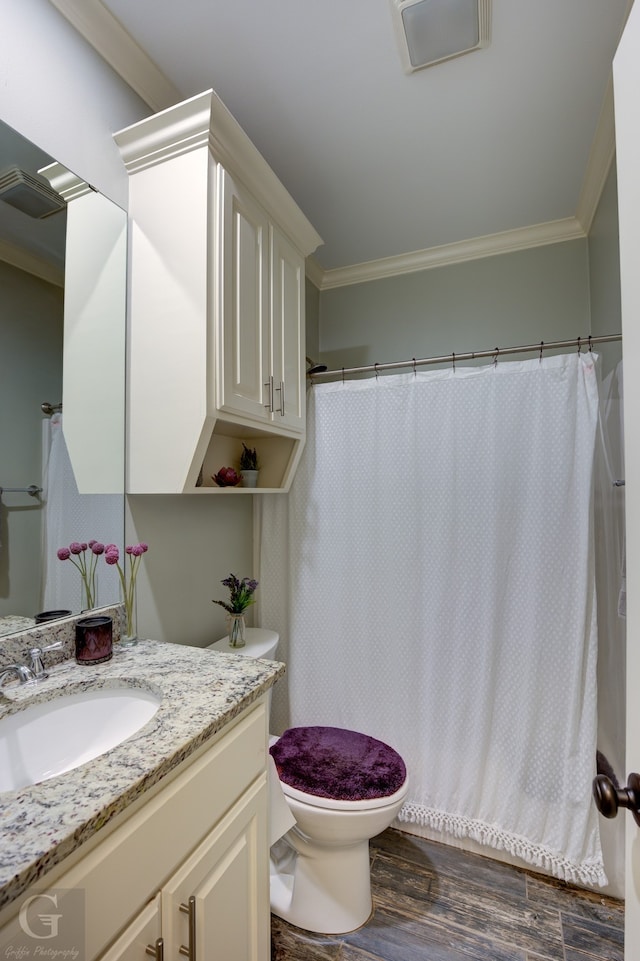 bathroom featuring vanity, ornamental molding, wood-type flooring, and toilet