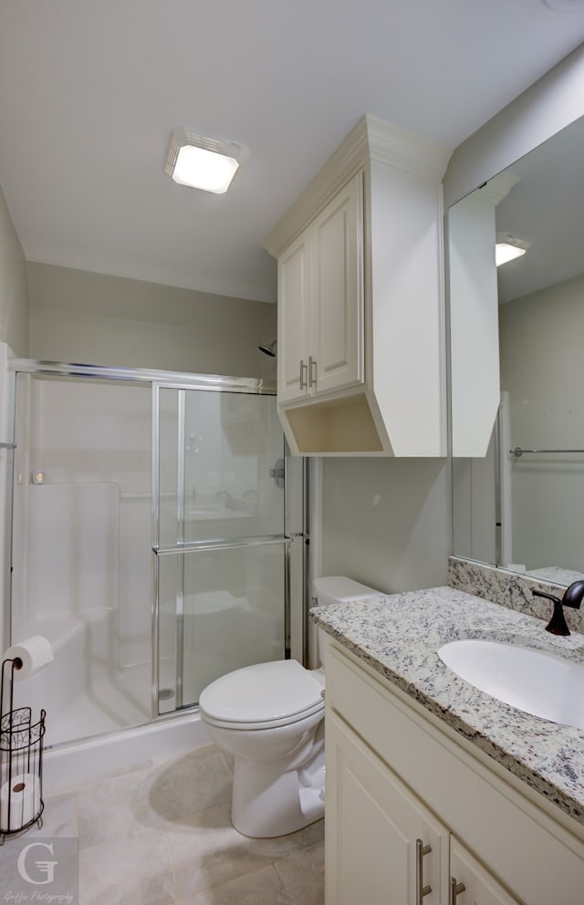 bathroom featuring vanity, toilet, walk in shower, and tile patterned flooring