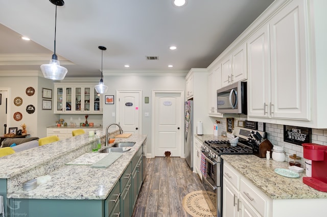 kitchen with appliances with stainless steel finishes, pendant lighting, and white cabinetry