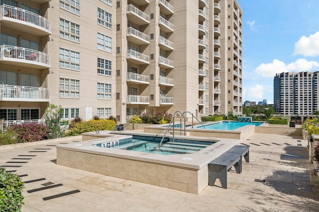 view of swimming pool featuring a hot tub