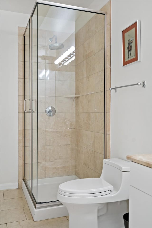 bathroom with toilet, tile patterned flooring, vanity, and walk in shower