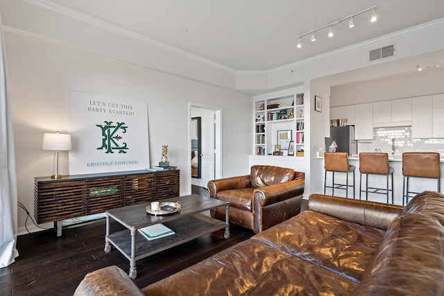 living room featuring crown molding, sink, built in features, and dark hardwood / wood-style floors