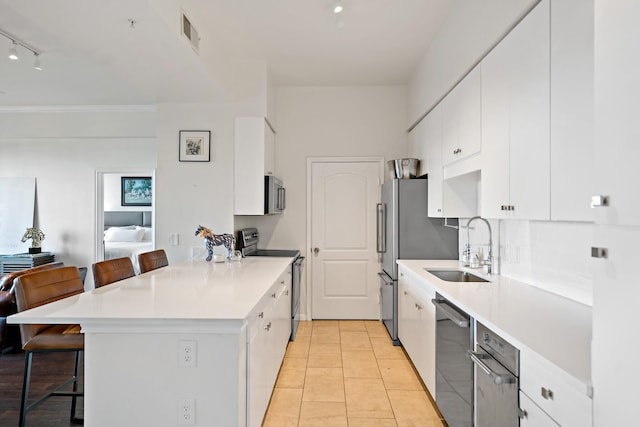 kitchen with white cabinets, stainless steel appliances, and a breakfast bar area