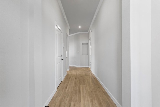 hall with light hardwood / wood-style flooring and crown molding