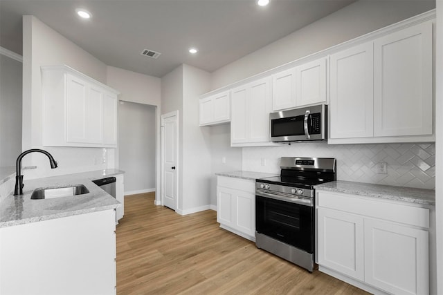 kitchen featuring white cabinets, appliances with stainless steel finishes, and sink