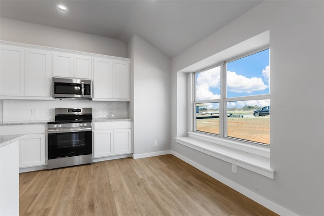 kitchen featuring a wealth of natural light, stainless steel appliances, white cabinetry, and tasteful backsplash