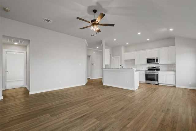 unfurnished living room with ceiling fan, wood-type flooring, and sink