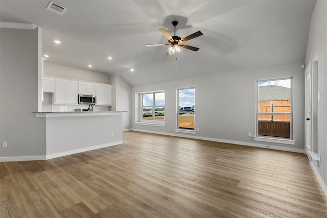 unfurnished living room with ceiling fan, light hardwood / wood-style floors, and lofted ceiling