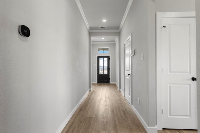 hallway with light hardwood / wood-style floors and crown molding