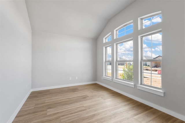 unfurnished room with light hardwood / wood-style floors and lofted ceiling