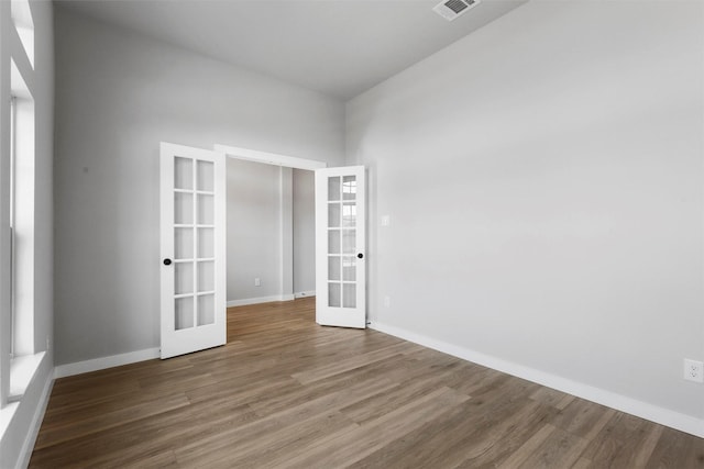 unfurnished room featuring french doors and dark hardwood / wood-style floors