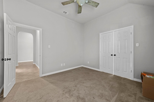 unfurnished bedroom with lofted ceiling, carpet floors, ceiling fan, and a closet