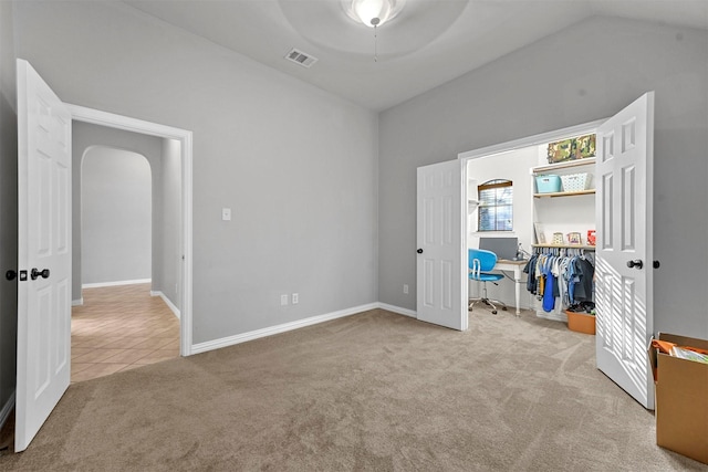 unfurnished bedroom featuring lofted ceiling and carpet