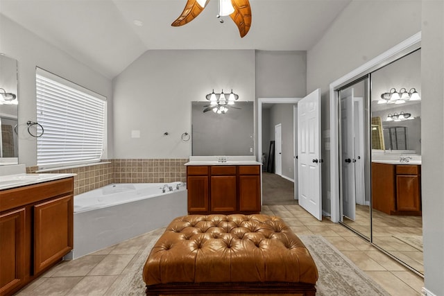 bathroom featuring a tub to relax in, tile patterned flooring, lofted ceiling, and vanity