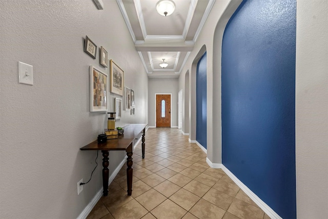 hall featuring ornamental molding, a raised ceiling, and light tile patterned floors