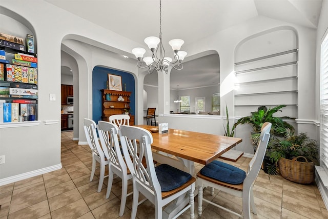 dining area with light tile patterned flooring, a chandelier, and built in features