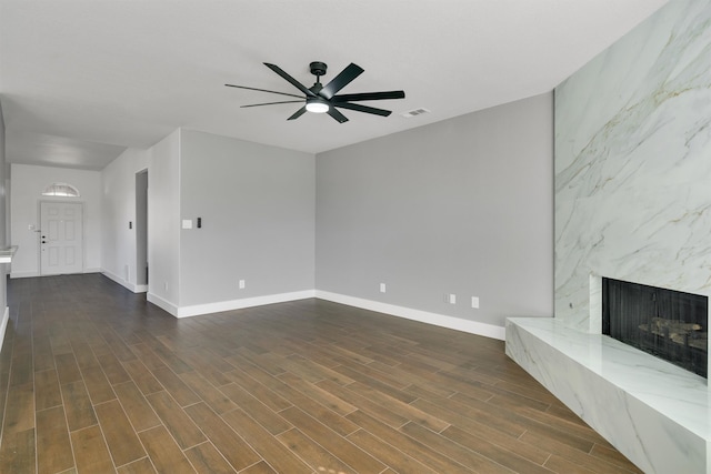 unfurnished living room with a fireplace, dark hardwood / wood-style floors, and ceiling fan