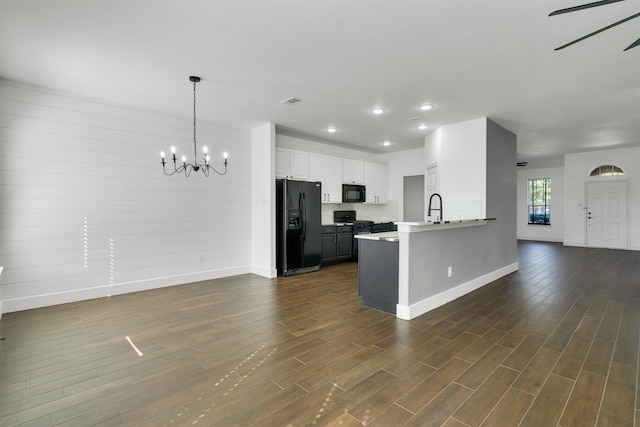 kitchen with black appliances, white cabinets, kitchen peninsula, and dark hardwood / wood-style flooring