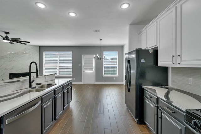 kitchen featuring dark wood-type flooring, stainless steel appliances, plenty of natural light, and white cabinets