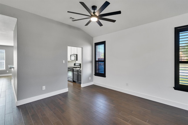 spare room featuring dark wood-type flooring, ceiling fan, lofted ceiling, and a wealth of natural light