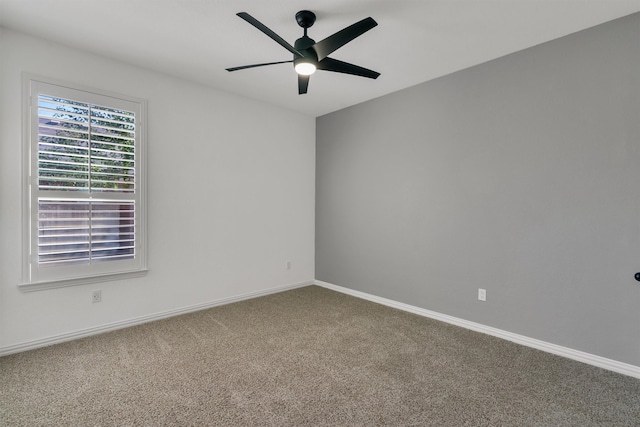 carpeted spare room featuring ceiling fan