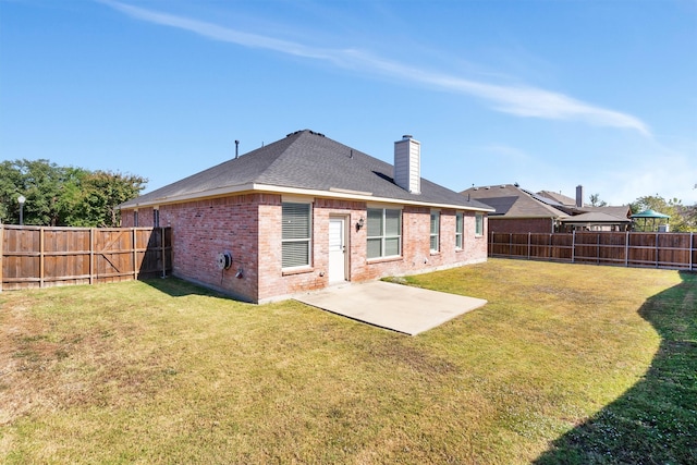 rear view of house featuring a yard and a patio area