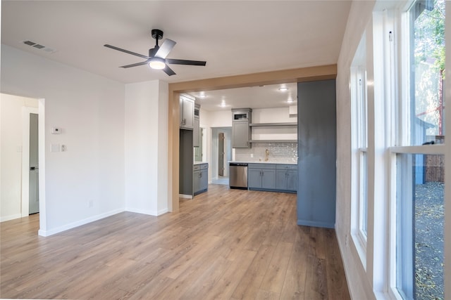 kitchen featuring decorative backsplash, ceiling fan, gray cabinets, dishwasher, and light hardwood / wood-style floors