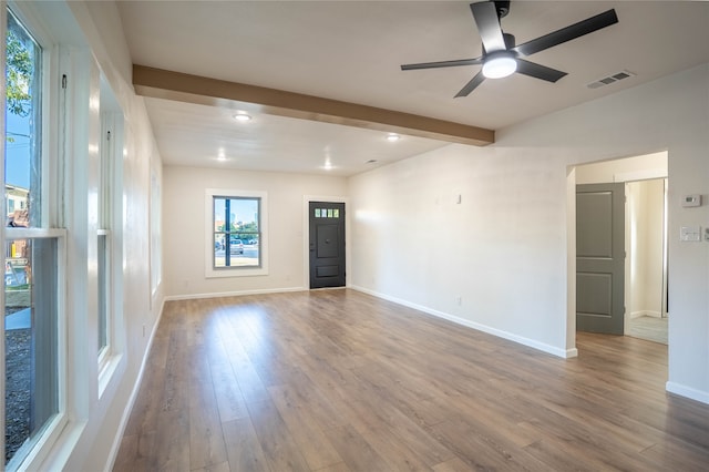 unfurnished room with hardwood / wood-style flooring, ceiling fan, a healthy amount of sunlight, and beamed ceiling