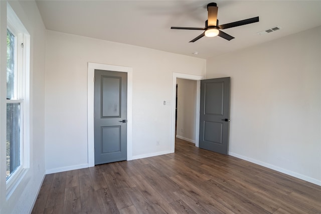 unfurnished bedroom with dark hardwood / wood-style flooring and ceiling fan