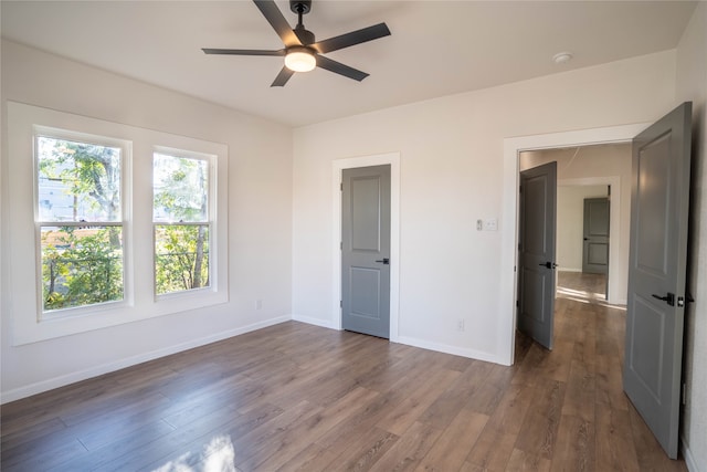 unfurnished bedroom featuring dark hardwood / wood-style floors and ceiling fan