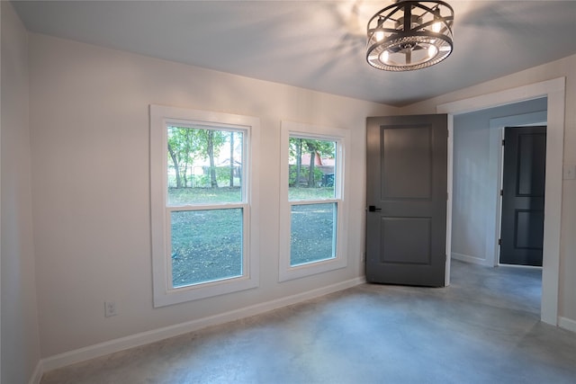 unfurnished room featuring a chandelier and lofted ceiling