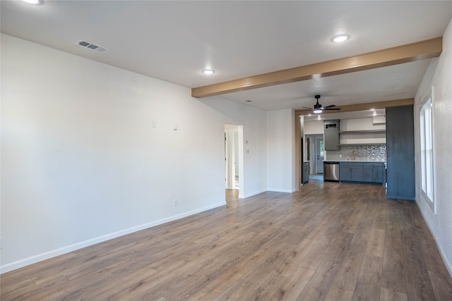 unfurnished living room with hardwood / wood-style floors, ceiling fan, and beam ceiling