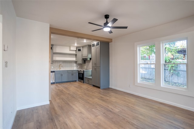 kitchen featuring gray cabinetry, ceiling fan, light wood-type flooring, appliances with stainless steel finishes, and tasteful backsplash