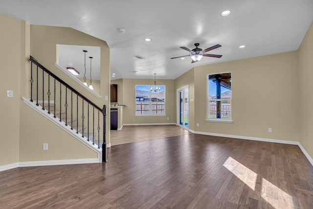 unfurnished living room with lofted ceiling, dark hardwood / wood-style floors, and ceiling fan with notable chandelier