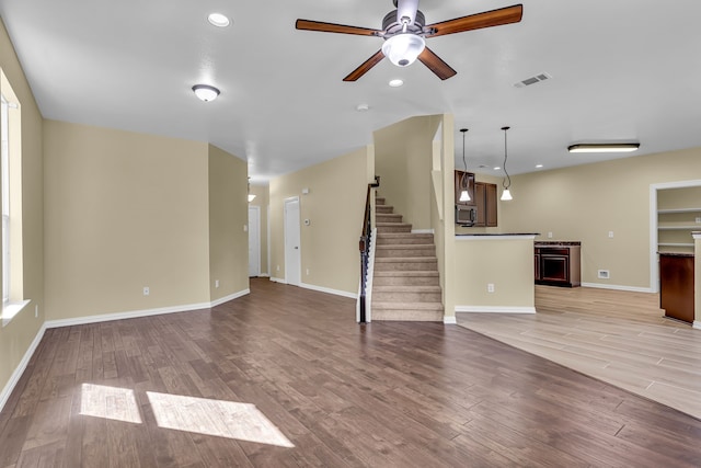 unfurnished living room with light hardwood / wood-style floors and ceiling fan