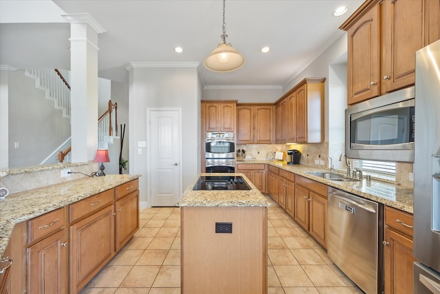 kitchen with sink, appliances with stainless steel finishes, hanging light fixtures, a center island, and light stone counters