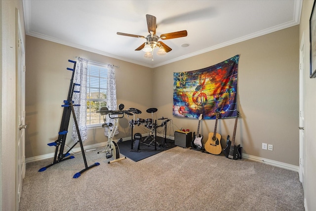exercise room featuring baseboards, ornamental molding, a ceiling fan, and carpet flooring
