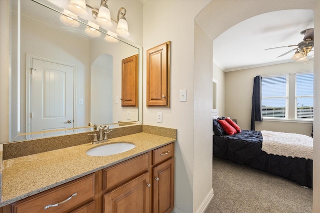 bathroom featuring vanity, a ceiling fan, crown molding, and baseboards
