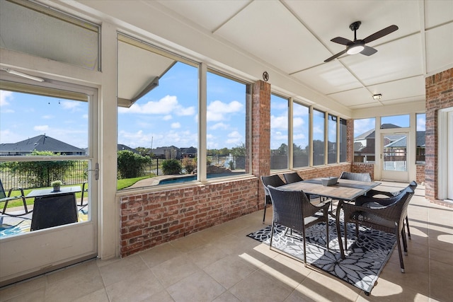sunroom / solarium with a ceiling fan and outdoor dining space