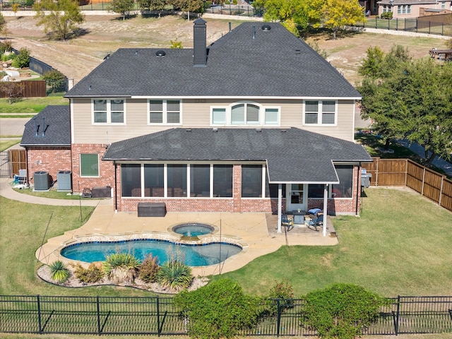 back of house featuring a patio area, a sunroom, central air condition unit, and a lawn