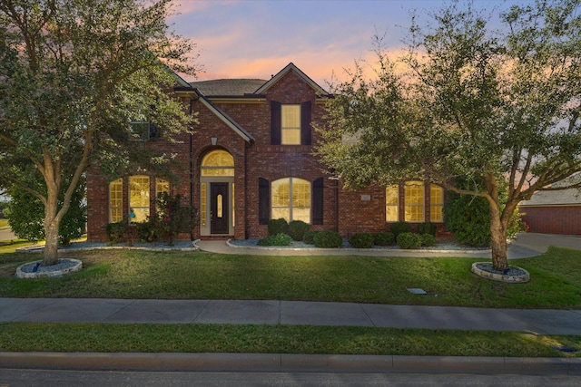 view of front of home with a front yard and brick siding