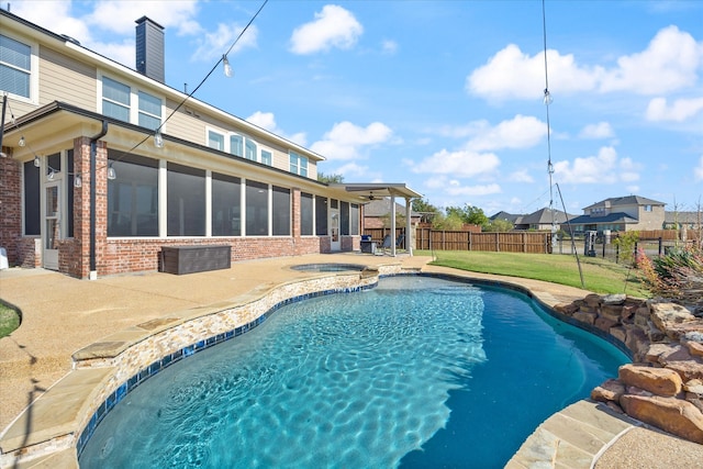 view of swimming pool featuring a lawn, a sunroom, a patio, and an in ground hot tub