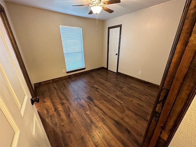 empty room with dark hardwood / wood-style floors and ceiling fan