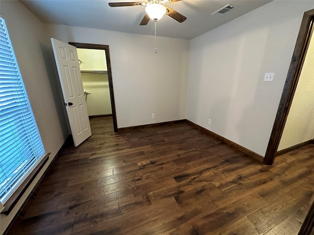 unfurnished room featuring ceiling fan and dark wood-type flooring