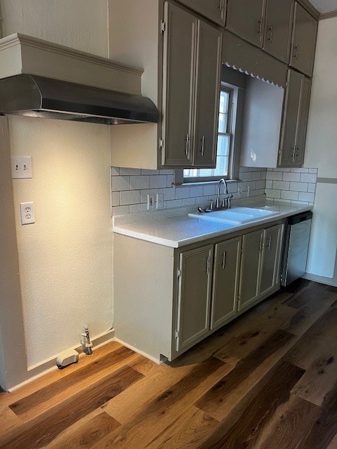 kitchen featuring decorative backsplash, dark hardwood / wood-style floors, sink, gray cabinets, and stainless steel dishwasher