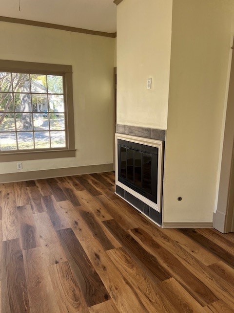 unfurnished living room with crown molding and dark hardwood / wood-style flooring